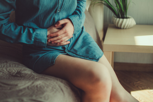 pessoa-que-sofre-de-tpm-e-dor-menstrual-no-quarto-em-casa-tendo-dor-de-estomago-dor-abdominal-por-causa-de-dias-criticos-inflamacao-e-inf